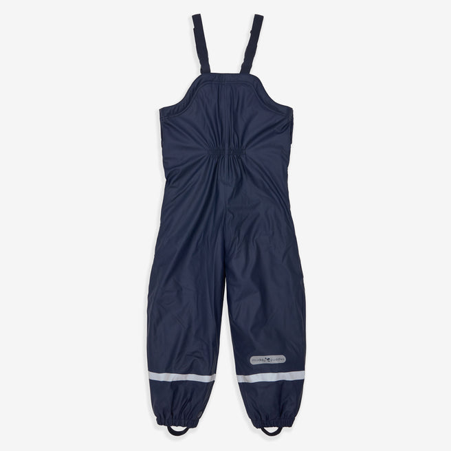 Navy Puddleflex waterproof dungarees with fleece lining, lying flat, unwrinkled, on a white background, with reflective stripes near the ankle.
